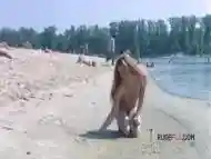 Playful blond nudist teen caught on camera naked at the beach