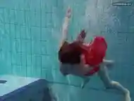 Red Dressed teen swimming with her eyes opened