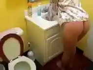 Brunette with a pierced belly takes a pee