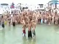 Sexy beach girls fighting each other from the shoulders of their boyfriends