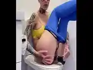 Bald slut in toilet mastrubirating to orgasm and then pissing, dildo in condom