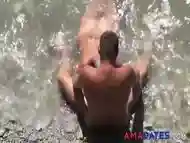 Girl sucks dick her boyfriend in the surf at a public beach